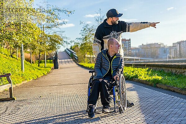 Eine behinderte Person im Rollstuhl mit einem Assistenten bei einem Spaziergang durch die Stadt