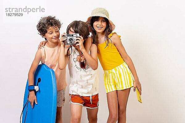 Kinder Sommerferien auf einem weißen Hintergrund  Junge nimmt ein Foto mit Vintage-Kamera Blick auf Kamera