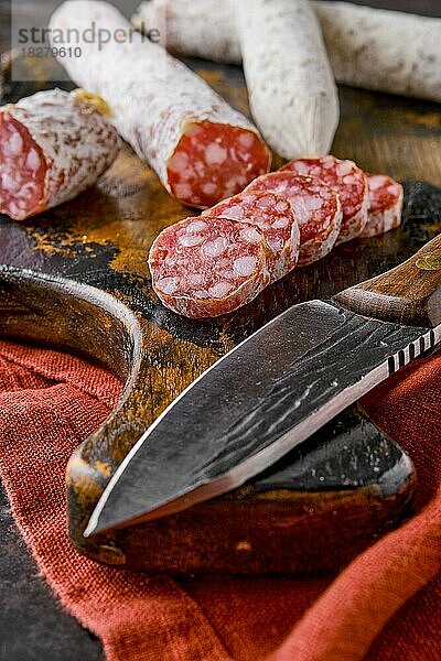 Fermentierte luftgetrocknete Salami auf Holzbrett in Scheiben geschnitten  Nahaufnahme