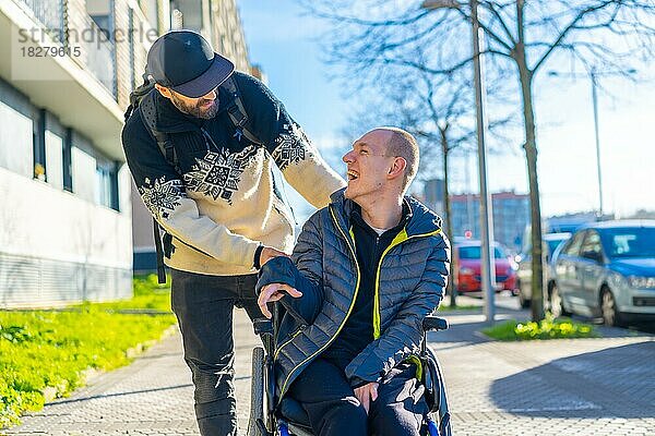 Eine behinderte Person im Rollstuhl mit einem lächelnden Freund  behinderte Normalität