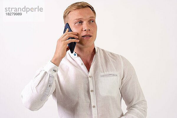 Kaukasischer blonder Geschäftsmann  der einen Arbeitsanruf mit dem Telefon auf einem weißen Hintergrund macht
