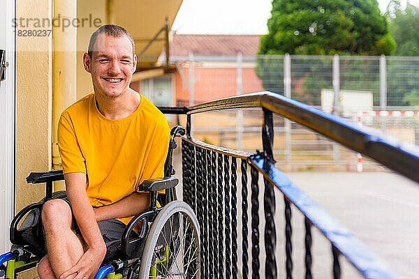 Gelb gekleidete behinderte Person in einem Rollstuhl in der Schule lächelt
