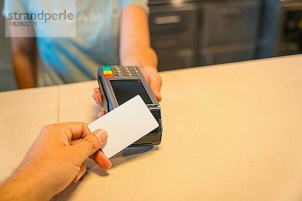 Unbekannte Kellnerin  die dem Kunden das Datentelefon übergibt  um den Kontakt mit der Kreditkarte des Kunden aufzunehmen