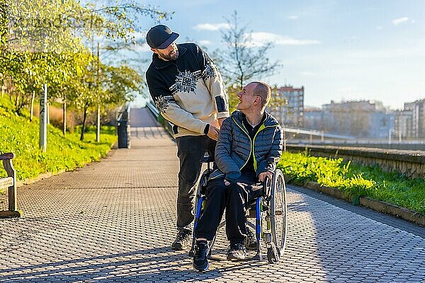 Eine behinderte Person im Rollstuhl mit einem Assistenten bei einem Spaziergang durch die Stadt