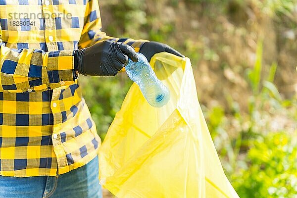 Unbekannte Person  die in einem Wald Plastik sammelt. Ökologie-Konzept  Recycling