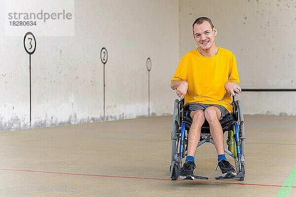 Eine behinderte Person im Rollstuhl bei einem baskischen Pelota-Spiel in Fronton