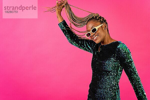 Afrikanische junge Frau mit Partyzöpfen auf rosa Hintergrund  Studioportrait mit Spaß