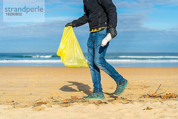 Meeresverschmutzung  unerkennbare Person  die am Strand Plastik im Sand sammelt. Ökologiekonzept