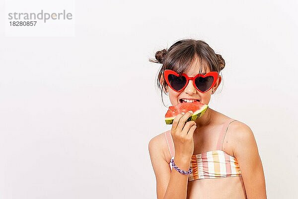 Mädchen genießt den Sommer und isst eine Wassermelone  Schulferien Konzept. Weißer Hintergrund