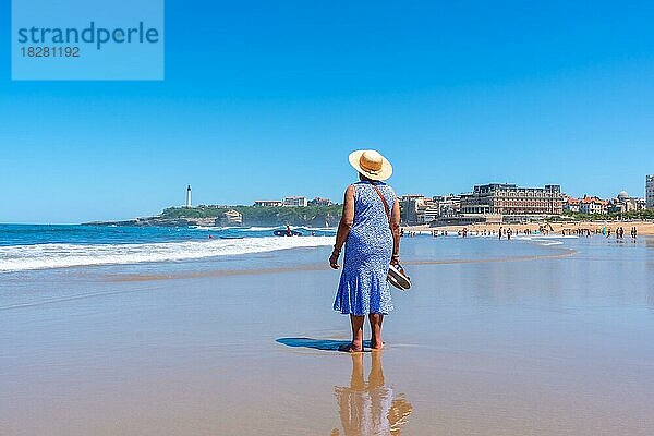 Eine ältere Frau mit Hut geht am Strand von Biarritz  Lapurdi  spazieren. Frankreich  südwestlicher Badeort