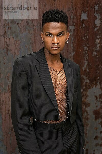 Schwarzer ethnischer Mann in einer modischen Pose auf einem metallischen Hintergrund