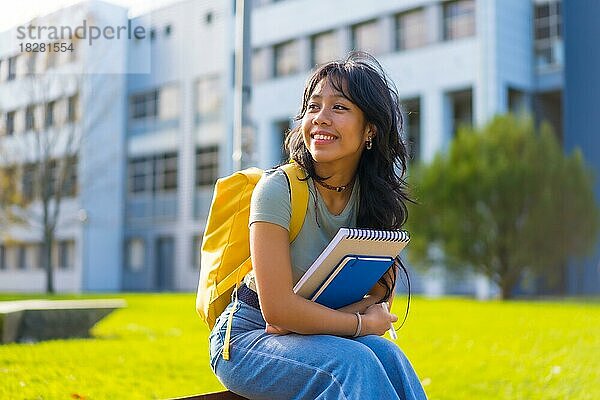 Asiatisches Mädchen auf dem Campus  Studentin genießt den Unterricht  lächelnd im College  sitzend lächelnd