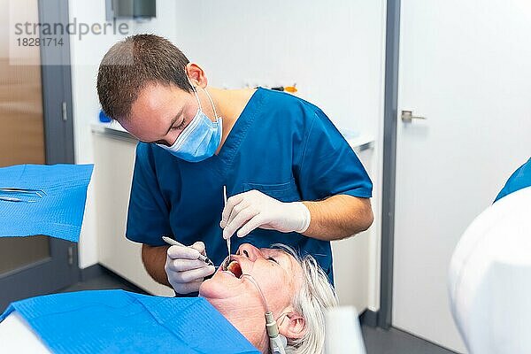 Zahnklinik  ältere Frau beim Zahnarzt  Überprüfung von Implantaten mit Zahnarzt  Gesichtsmaske