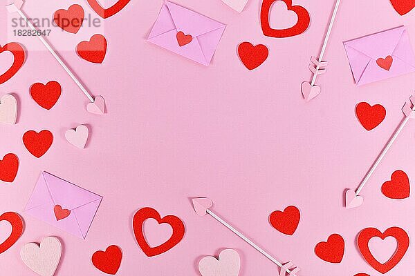 Valentinstag flach legen mit Liebe Buchstaben  Amor Pfeile und rote Herzen Konfetti bilden Grenze um rosa Hintergrund