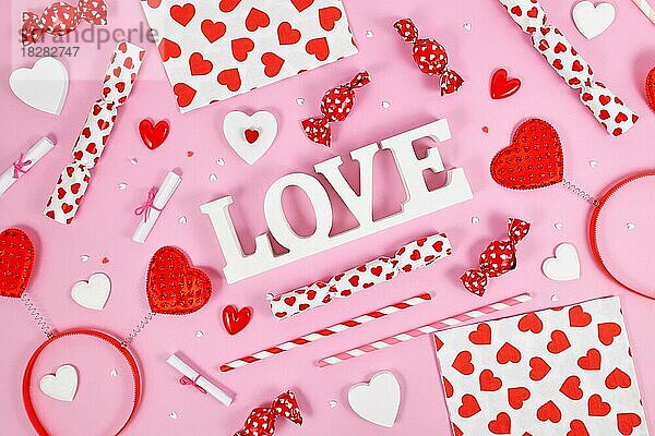 Valentinstag Dekoration mit Liebe Text  Herz Ornamente und Streusel auf rosa Hintergrund