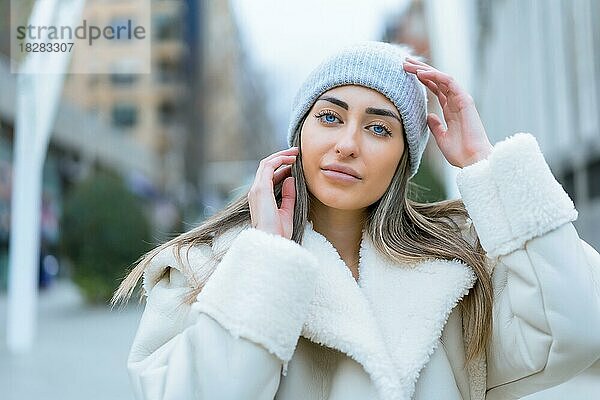 Winterporträt einer kaukasischen Frau mit Wollmütze in der Stadt  Lebensstil