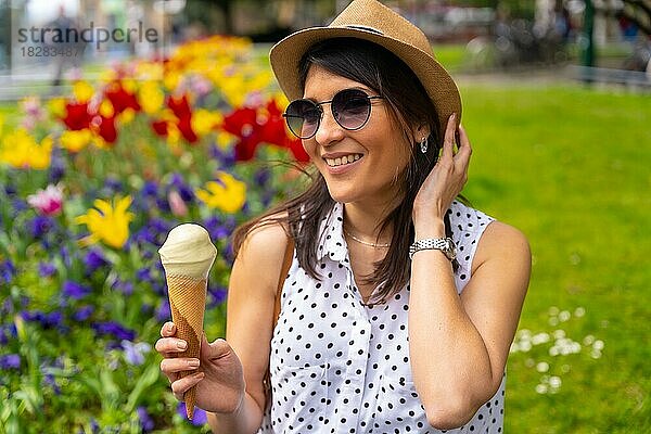 Eine Touristin  die die Stadt besucht  isst ein Pistazieneis  genießt die Sommerferien und hat eine Kamera dabei  Konzept der Alleinreisenden