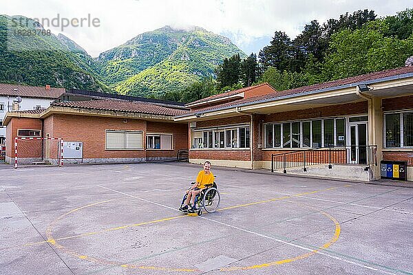 Eine gelb gekleidete behinderte Person in einem Rollstuhl auf dem Schulhof