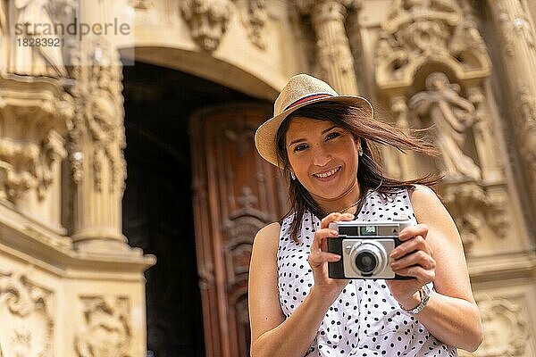 Touristin mit Hut  die eine Kirche besichtigt und Fotos mit einer Kamera macht  die Frühlings- oder Sommerferien genießt  Konzept einer weiblichen Reisenden und Schöpferin digitaler Inhalte