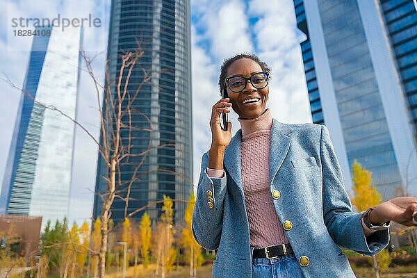Unternehmensporträt einer schwarzen ethnischen Geschäftsfrau im Gewerbegebiet  die am Telefon spricht