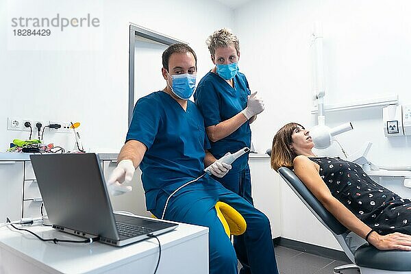 Zahnklinik  Zahnarzt bei der Vorbereitung des neuen Scanners für die Herstellung von 3D-Prothesen  Erläuterung der Funktionsweise