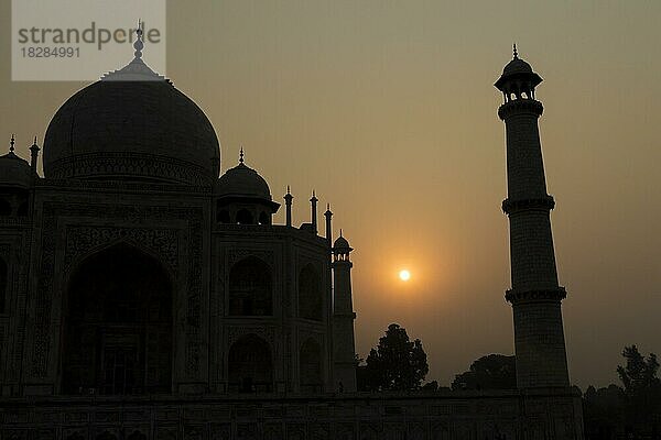 Taj Mahal im Gegenlicht der aufgehenden Sonne  das Hauptgebäude des Mausoleums und ein Minarett. Weltwunder  UNESCO-Weltkulturerbe  berühmtes Wahrzeichen und Touristenattraktion. Agra  Uttar Pradesh  Indien  Asien