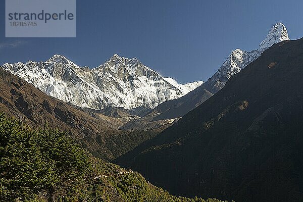 Blick auf die Achttausender von Namche Bazaar aus: Mount Everest und Lhotse  der höchste und der vierthöchste Berg der Welt. Der Lhotse befindet sich in der Mitte des Bildes  links davon erstreckt sich der Lhotse-Nuptse-Grat über eine Reihe von Gipfeln  die zum Nuptse gehören. Der Everest  der in Nepal Sagarmatha und in Tibet Chomolungma heißt  liegt hinter diesem Grat  oben. Die Ama Dablam liegt rechts  das Dudh Koshi-Tal darunter. Everest-Basislager-Trek  Himalaya  Sagarmatha-Nationalpark  Khumbu-Region  Solukhumbu  Nepal  Asien