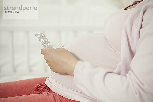 Schwangere Frau mit Tabletten in der Hand | MR:yes NH_schwangerenbauch_mr