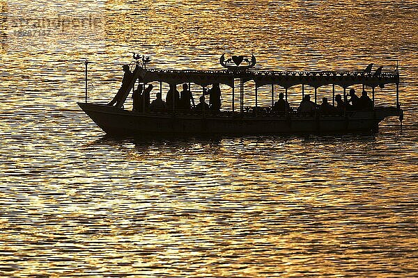 Silhouette eines Wassertaxis mit Touristen auf dem Nil bei Sonnenuntergang  Ägypten  Afrika