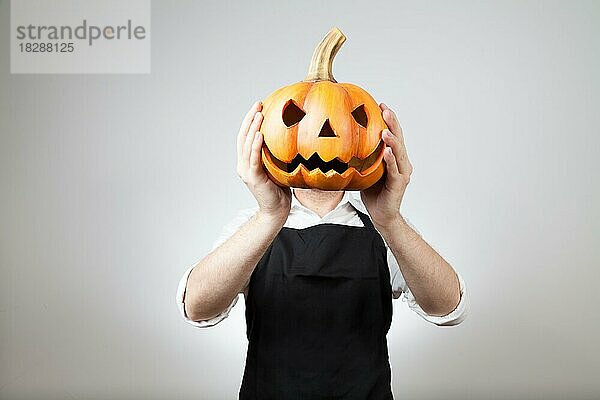 Mann mit Schürze hält sich einen Ton Kürbis vor seinen Kopf | MR:yes ph_halloween_mr