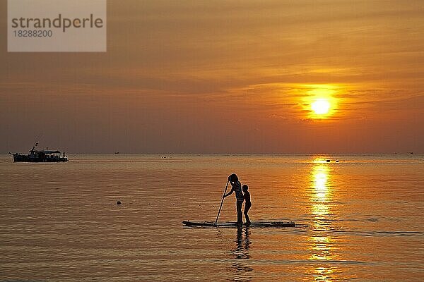 Mutter und Kind beim Standup-Paddleboarding  Silhouette im Sonnenuntergang  Insel Ko Tao  Koh Tao  Teil des Chumphon-Archipels in Südthailand