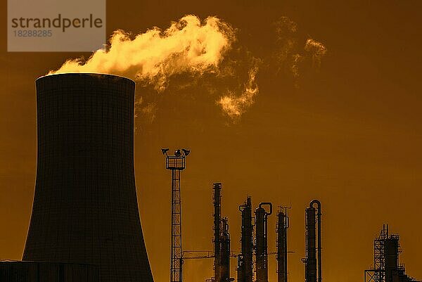 Industriegebiet mit Kühlturm als Silhouette im Sonnenuntergang auf dem Gelände der BASF-Chemieproduktion im Hafen von Antwerpen  Belgien  Europa