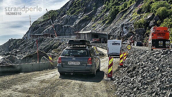 Straßenbaustelle  Pkw fährt über staubige Piste an Felsenküste  Küstenstraße  Lofoten  Norwegen  Europa