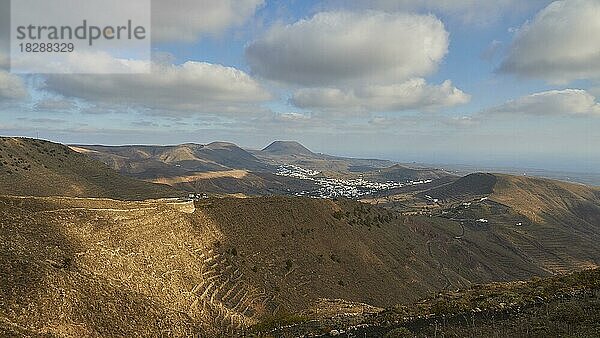 Terrassenförmige Felder  Lavahügel  Siedlung aus weißen Häusern  Blauer Himmel  weiße Wolken  Haria  Norden  Lanzarote  Kanarische Inseln  Spanien  Europa