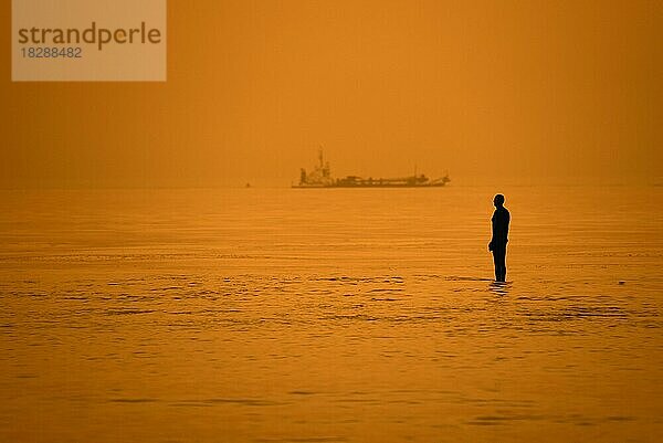 Skulptur Another Time XVI von Antony Gormley als Silhouette im Sonnenuntergang an der Nordseeküste bei Knokke-Heist  Westflandern  Belgien  Europa