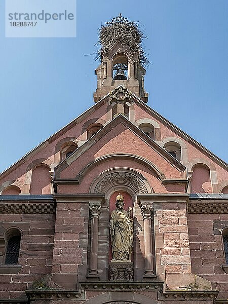 Der Dachteil der neoromanisch-byzantinischen St. Leo-Kapelle mit einem Storchennest auf dem Glockenturm und einer Skulptur an der Wand  Eguisheim  Haut-Rhin  Alsace  Elsass  Frankreich  Europa