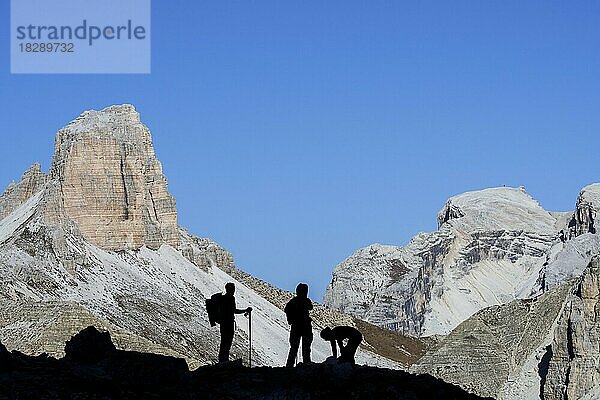 Drei Bergsteiger vor der Silhouette des Torre dei Scarperi  Schwabenalpenkopf  Sextner Dolomiten  Parco Naturale Tre Cime  Südtirol  Italien  Europa