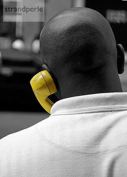 Afroamerikaner telefoniert mit gelben Telefonhörer  New York City  USA  Nordamerika