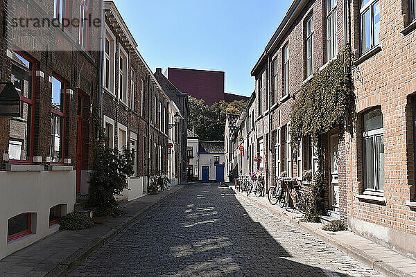 Belgien  Westflandern  Brügge  leere Kopfsteinpflasterstraße mit Reihen von Stadthäusern auf jeder Seite