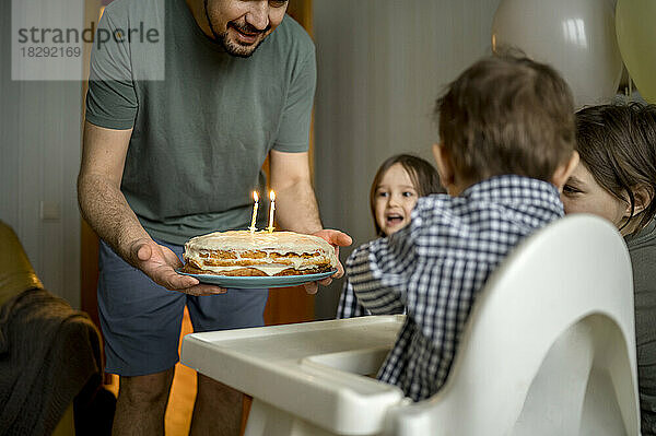 Fröhliche Familie feiert gemeinsam den Geburtstag ihres Sohnes zu Hause