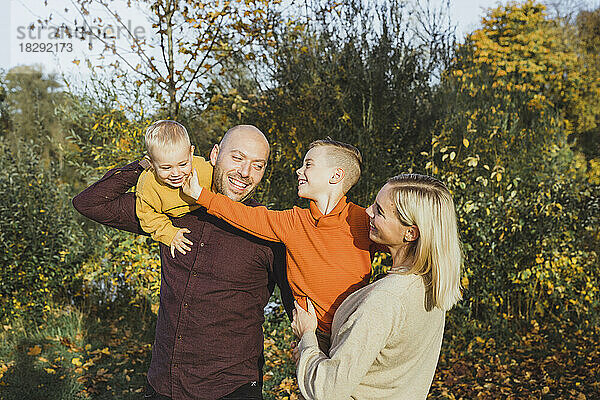 Lächelnde Eltern mit Kindern  die den Herbst genießen