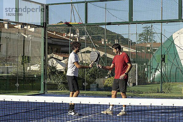 Freunde mit Tennisschlägern spielen auf dem Sportplatz