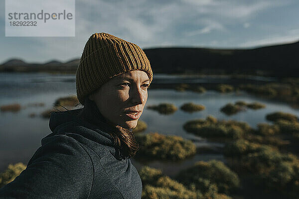 Frau mit Strickmütze am See