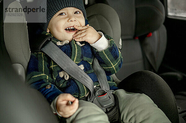 Happy boy in car safety seat