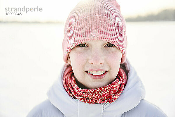 Fröhliches Mädchen mit Strickmütze im Winter