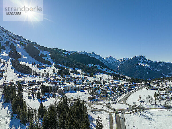 Deutschland  Bayern  Oberjoch  Sonne scheint über dem schneebedeckten Dorf in den Allgäuer Alpen