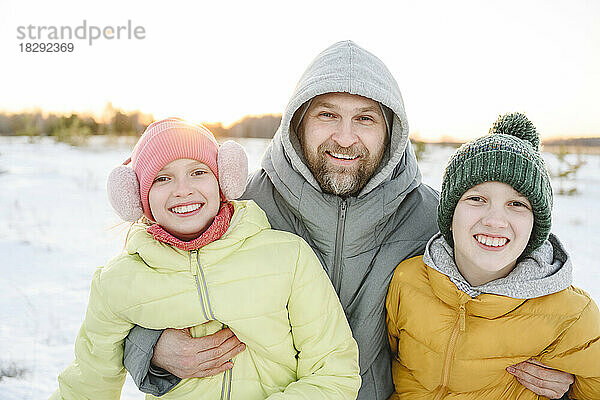 Glücklicher Vater mit Sohn und Tochter  die den Winter genießen