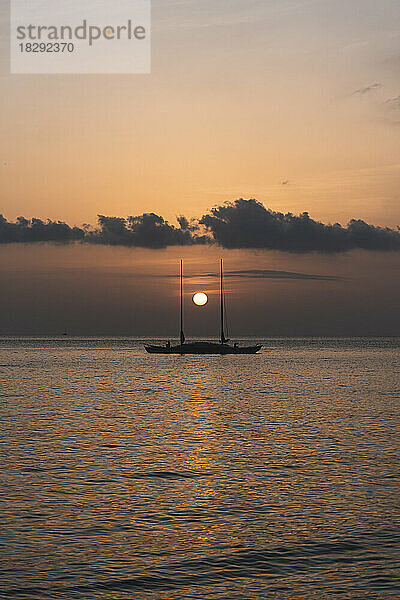 Spanien  Balearen  Sonnenuntergang über einem Segelboot  das auf dem Meer schwimmt