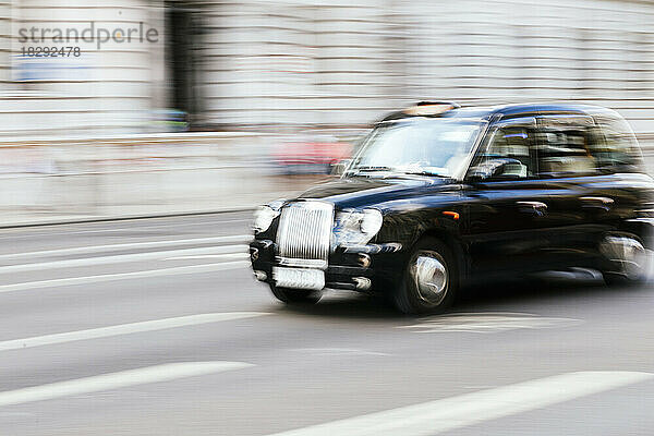 UK  England  London  Blurred motion of taxi driving along city street