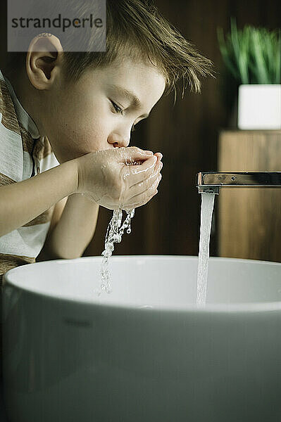 Junge putzt Zähne im Badezimmer zu Hause